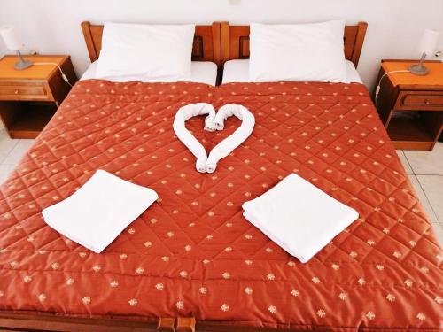 a bed with a heart made out of towels at Star Apartment in Kallithea Halkidikis