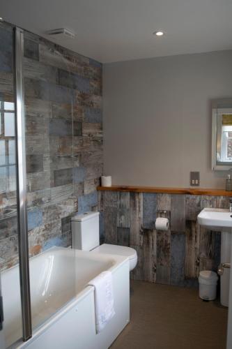a bathroom with a bath tub and a sink at The Porlock Weir Hotel in Porlock