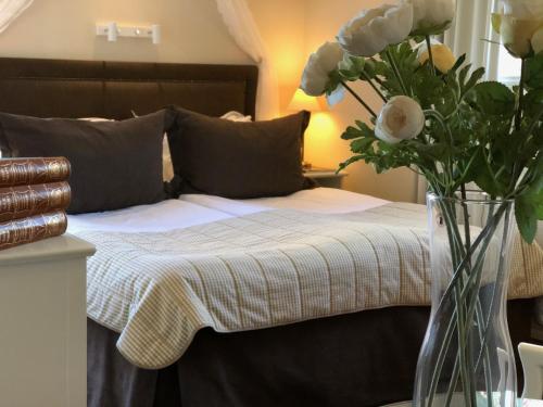 a bedroom with a bed with a vase of flowers at Åkerblads Hotell Gästgiveri Spa in Tällberg