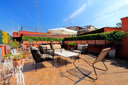 een patio met stoelen en tafels en een parasol bij Restart Accommodations Rome in Rome