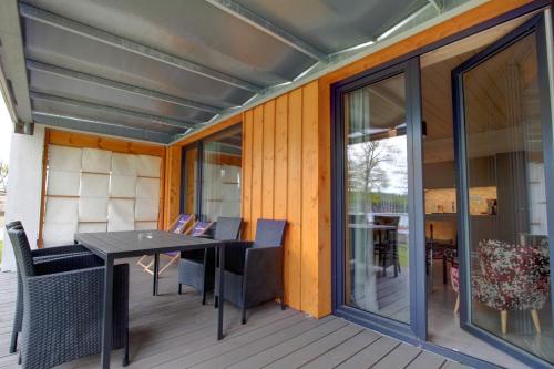 a patio with a table and chairs on a deck at Stranda in Giżycko