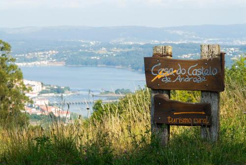 a sign on a hill with a view of a lake at Casa do Castelo de Andrade in Puentedeume