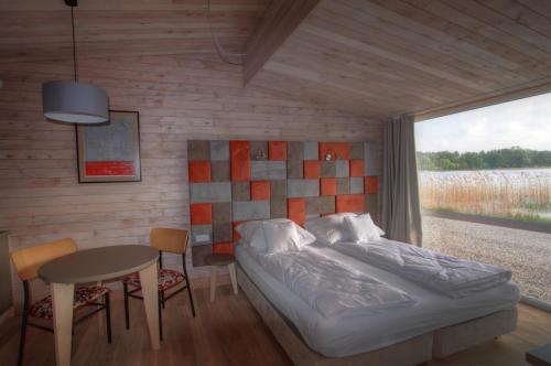 a bedroom with a bed and a table and chairs at Stranda in Giżycko