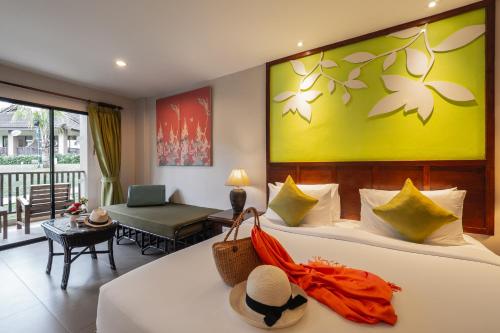 a bedroom with a large bed with a yellow wall at The Leaf Oceanside by Katathani - SHA Extra Plus in Khao Lak