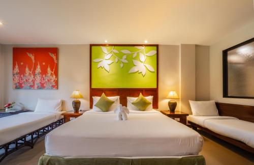 a hotel room with two beds and two couches at The Leaf Oceanside by Katathani - SHA Extra Plus in Khao Lak