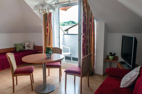 a living room with a table and chairs and a couch at Pension Hiesel-Villa Untersbergblick in Anthering