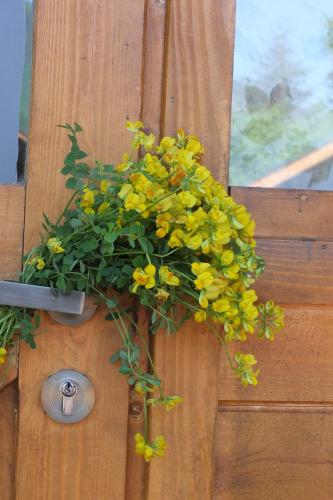 a bunch of yellow flowers on a wooden door at Mountain Cabins in Mestia