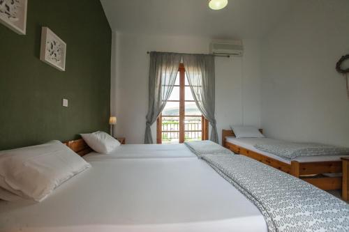 two twin beds in a room with a window at Sofia Apartments - Kantia in Kandia
