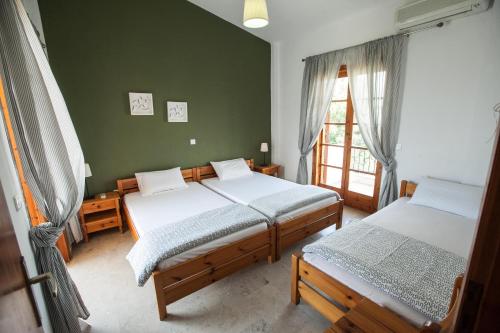 a bedroom with two beds and a window at Sofia Apartments - Kantia in Kandia