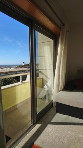 1 dormitorio con ventana y vistas al océano en Beach front sunset apartment, en Apúlia