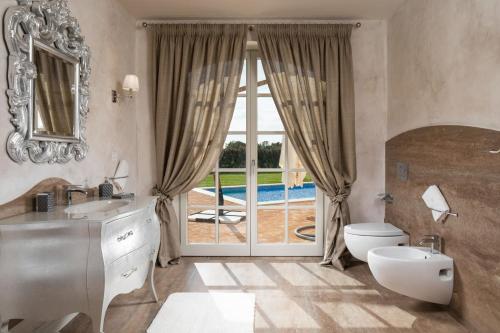 a bathroom with a sink and a toilet and a window at Villa Ivana in Vabriga