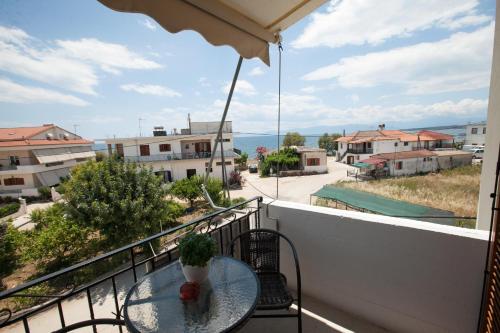 a table on a balcony with a view of the ocean at Sofia Apartments - Kantia in Kandia