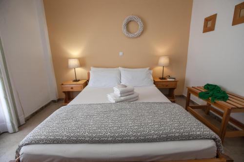 a bedroom with a large bed with two tables and two lamps at Sofia Apartments - Kantia in Kandia