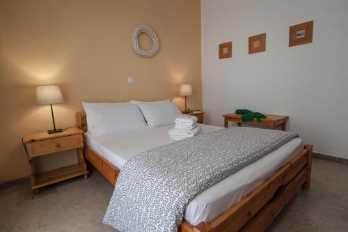 a bedroom with a large bed with two night stands at Sofia Apartments - Kantia in Kandia
