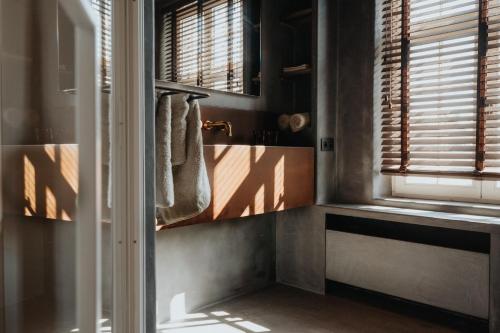 a bathroom with a window and a sink and towels at Amitié in Kinrooi
