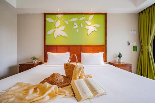 a bedroom with a bed with two books on it at The Leaf Oceanside by Katathani - SHA Extra Plus in Khao Lak