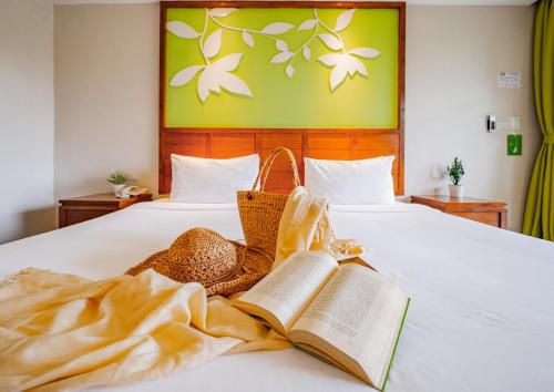 a bed with two books and baskets on it at The Leaf Oceanside by Katathani - SHA Extra Plus in Khao Lak