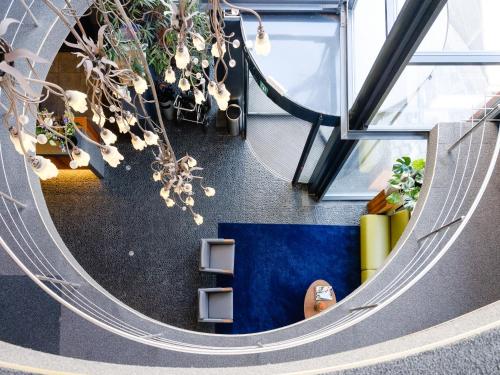an overhead view of an office lobby with plants at Ghent River Hotel in Ghent