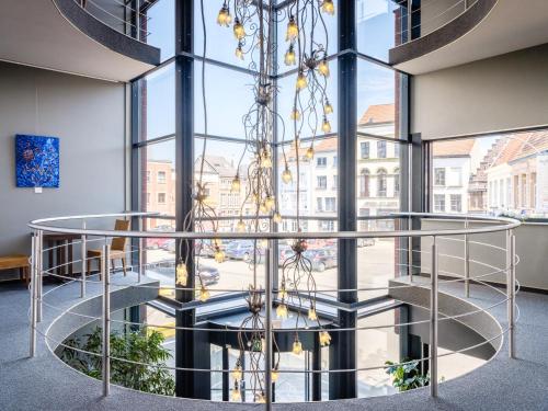 a spiral staircase in a building with a large window at Ghent River Hotel in Ghent
