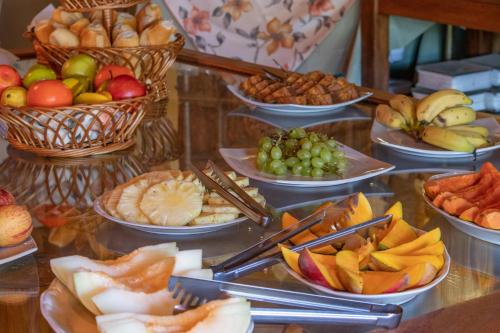 een buffet met verschillende soorten fruit en snacks bij Bomtempo Itaipava Hotel by Castelo Itaipava in Itaipava