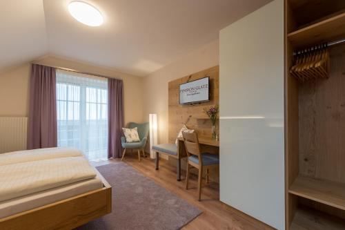 a bedroom with a bed and a desk and a table at Glatz Haus Siegesbrunn in Bad Waltersdorf