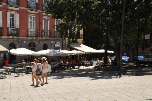 two women standing in a plaza with tables and umbrellas at EVA LUXURY ROOMS CAGLIARI in Cagliari