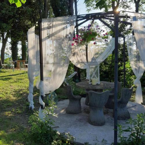 a gazebo with white curtains and a table at Ca'Lavalle B&B in Urbino
