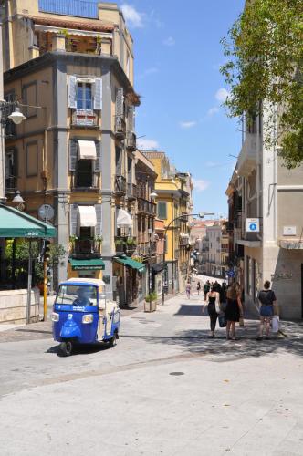 an old blue and white car parked on a city street at EVA LUXURY ROOMS CAGLIARI in Cagliari