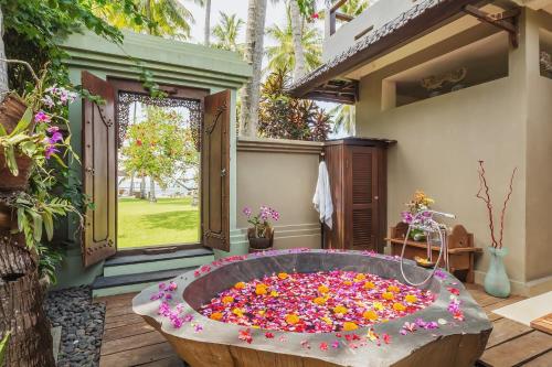 a large tub full of flowers in a yard at Oceanfront Citakara Sari Villas in Candidasa