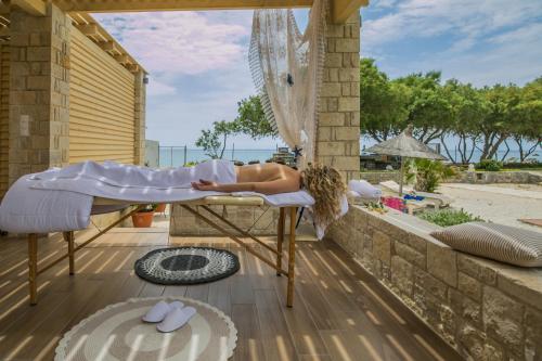a woman laying on a bed on a porch at Villa Pelagos in Koutsounari