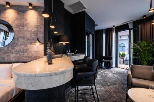 a living room with a bar with chairs and a couch at Hotel Adamo in Tbilisi City