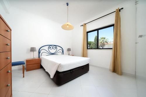 1 dormitorio con cama y ventana en Apartamentos Sol Nascente 2, en Vilamoura