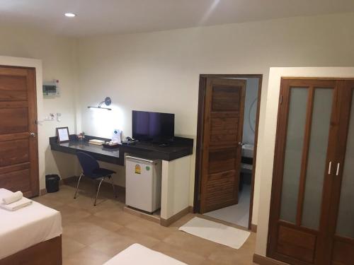 a room with a desk with a computer and a bed at Mamaungpaa Hill resort in Ta Khli
