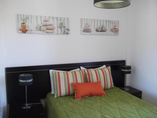 a bedroom with a green bed with two pillows at Quinta dos Carvalhais - Serra da Estrela in Fornos de Algodres
