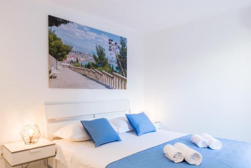 a bedroom with a large white bed with blue pillows at House of Cyril in Split