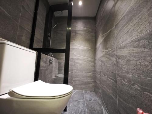 a bathroom with a toilet and a shower at Oikos Poshtel in Kota Kinabalu