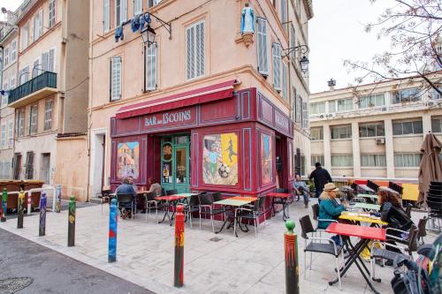 a restaurant with tables and chairs on a city street at L'escale in Marseille
