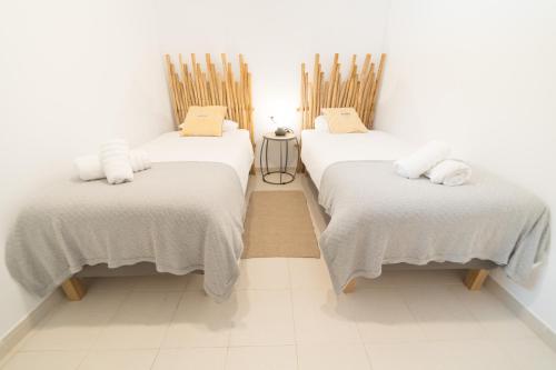 コラレホにあるRocky Point Villaの白いシーツが置かれたベッド2台が備わる客室です。