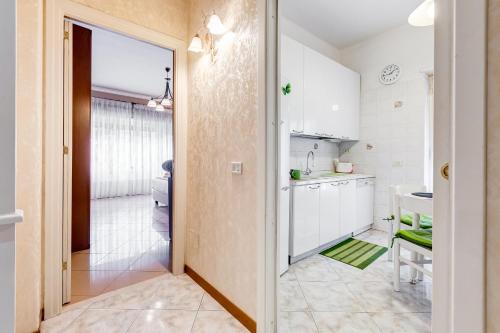 a kitchen with white cabinets and a door to a bathroom at J.N.D.Holidays in Rome