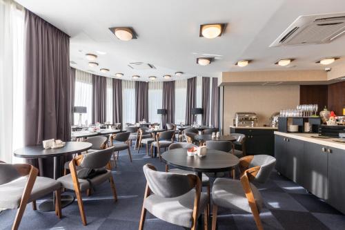 a restaurant with tables and chairs and a bar at Hotel Adamo in Tbilisi City