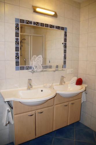 a bathroom with two sinks and a mirror at Haus Gaby in Holzgau