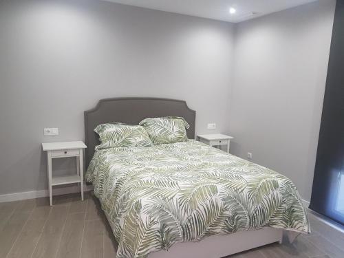 a bedroom with a bed with two night stands at Cosy flat near the beach & town centre in Fuengirola