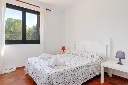 1 dormitorio blanco con 2 camas y ventana en La Quinta Punyeta, en Tamariu