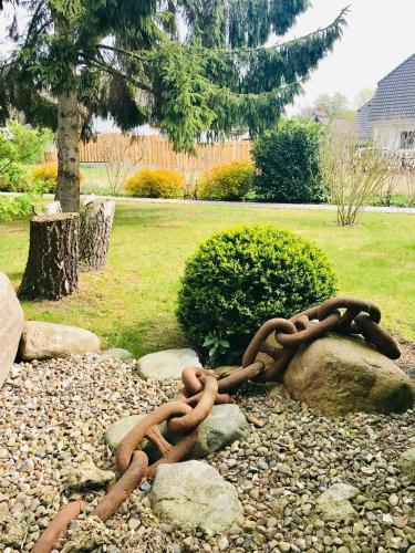 a rusty chain laying on a pile of rocks at "Schiffszimmermannshaus" by Ferienhaus Strandgut in Born