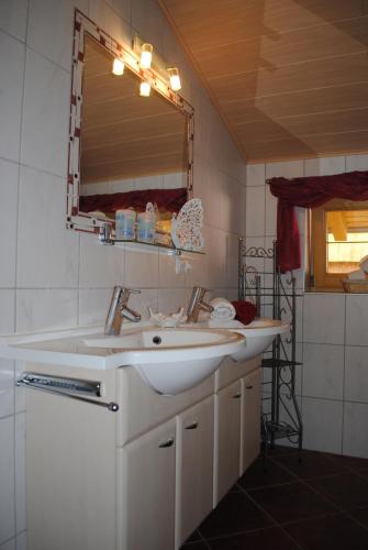 a bathroom with a white sink and a mirror at Haus Gaby in Holzgau