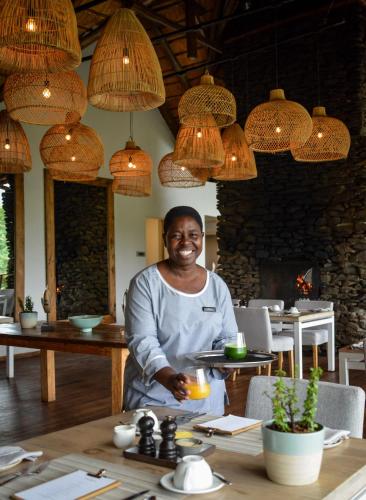 a man standing at a table in a restaurant at Lion Sands Narina Lodge in Sabi Sand Game Reserve