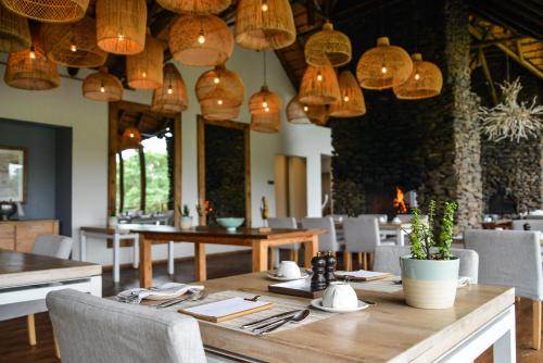 uma sala de jantar com mesa, cadeiras e luzes em Lion Sands Narina Lodge em Sabi Sand Game Reserve