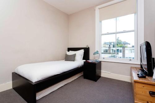 ロンドンにあるVeeve - Heaven in Highgateのベッドルーム(ベッド1台、テレビ、窓付)