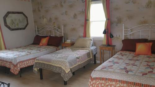 Zimmer mit 2 Betten und einem Fenster in der Unterkunft Midway Lodging in Cornish