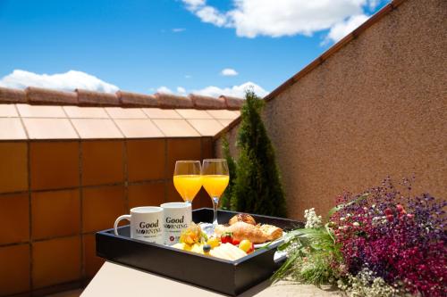 a tray of food and two glasses of orange juice at Hotel Exe Reina Isabel in Ávila